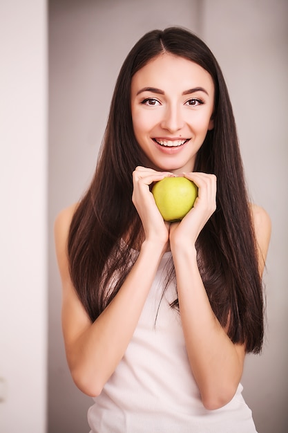 Mujer delgada sostenga en la mano manzana verde