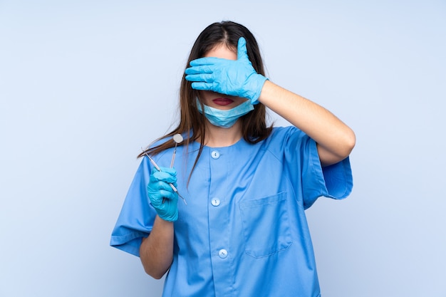 Foto mujer dentista cubriendo sus ojos