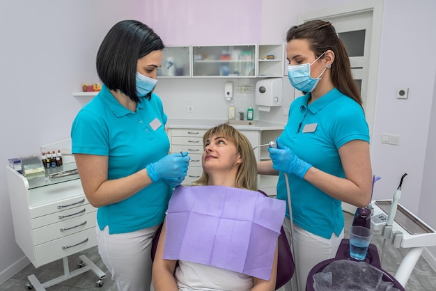 Mujer dentista hablando con su paciente sobre el tratamiento de sus dientes