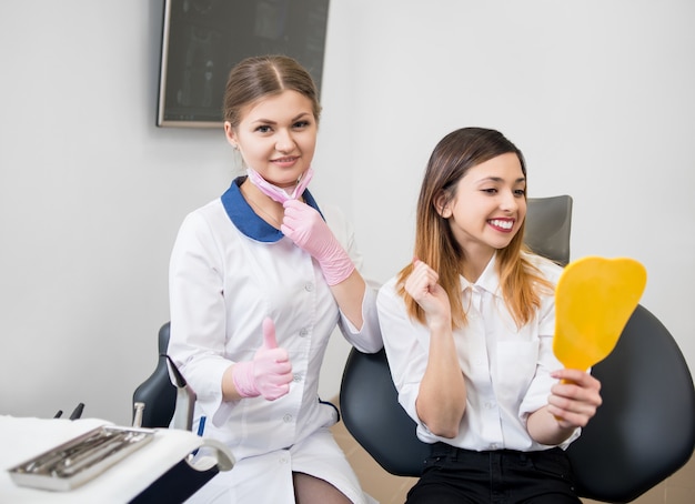 Foto mujer dentista con paciente en consultorio dental