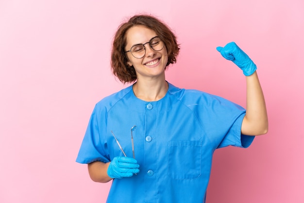 Mujer dentista posando aislada contra la pared en blanco