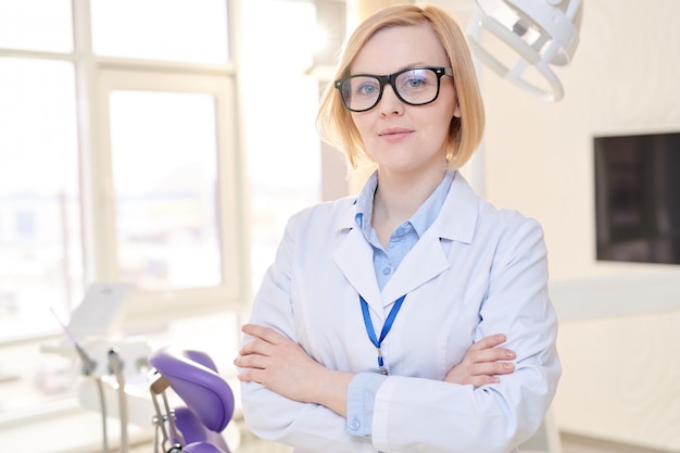 Mujer dentista posando en clínica moderna