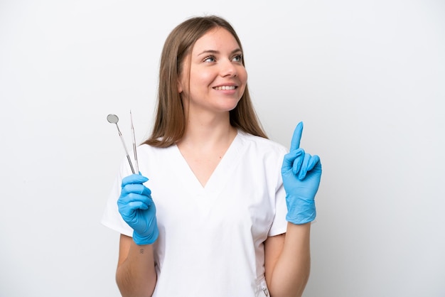 Mujer dentista sosteniendo herramientas aisladas sobre fondo blanco apuntando hacia una gran idea