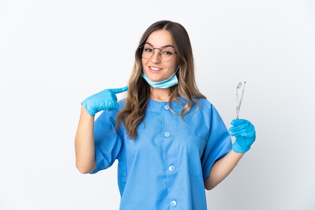 Foto mujer dentista sosteniendo herramientas posando aislado contra la pared en blanco