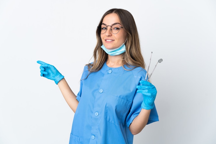Foto mujer dentista sosteniendo herramientas sobre dedo acusador aislado hacia el lado
