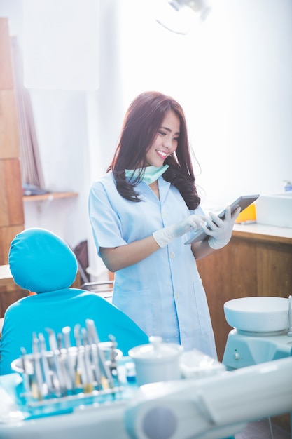 Mujer dentista con tableta sobre clínica de consultorio médico