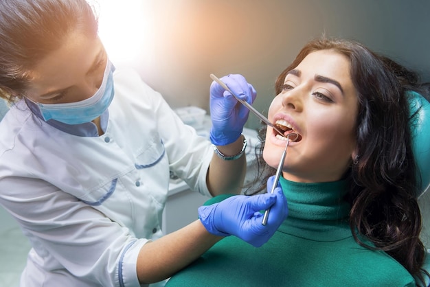 Mujer dentista en el trabajo sonda y espejo bucal