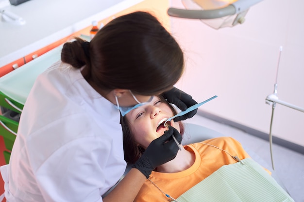 Mujer dentista tratando a una niña