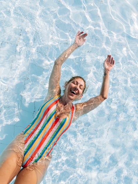 Mujer dentro de la piscina disfrutando feliz