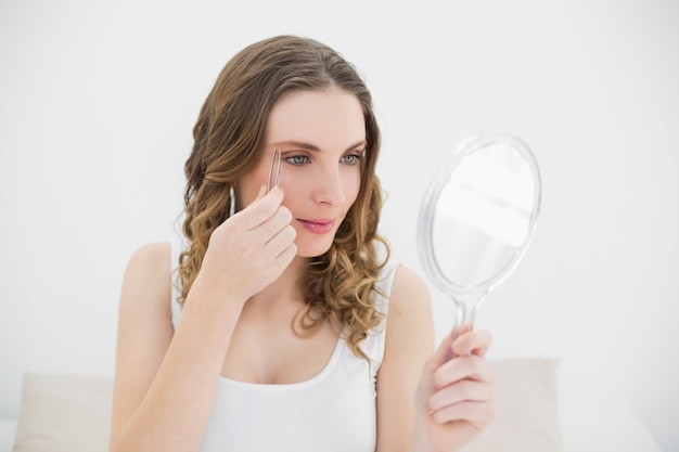 Mujer depilando sus cejas