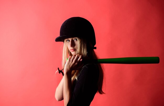 Foto mujer en el deporte de béisbol concepto de jugadora de béisbol suave pero acertadamente chica tierna rubia usar casco sostener bate de béisbol fondo rojo patear centrado en el resultado mujer disfrutar jugar béisbol