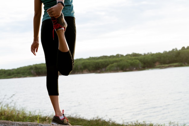 Foto la mujer del deporte está estirando el músculo después del entrenamiento