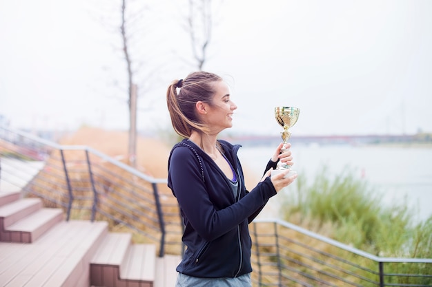 Foto mujer deporte sosteniendo un trofeo