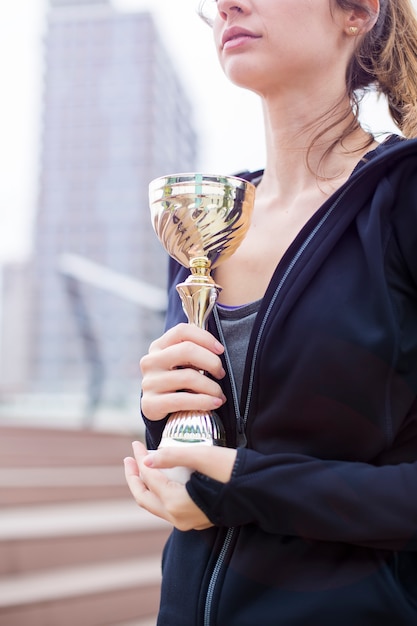 Mujer deporte sosteniendo un trofeo