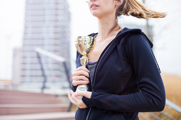 Mujer deporte sosteniendo un trofeo