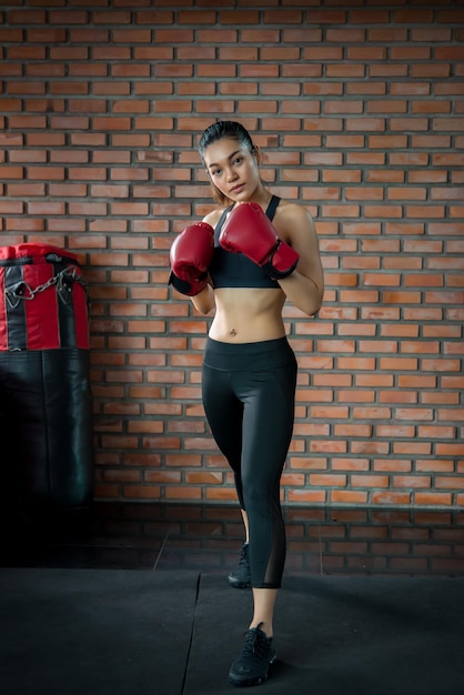 Mujer deportista asiática usa guante de boxeo en el gimnasioEntrenamiento de personas de TailandiaLo mejor de luchar contra ellaMujer fuerte