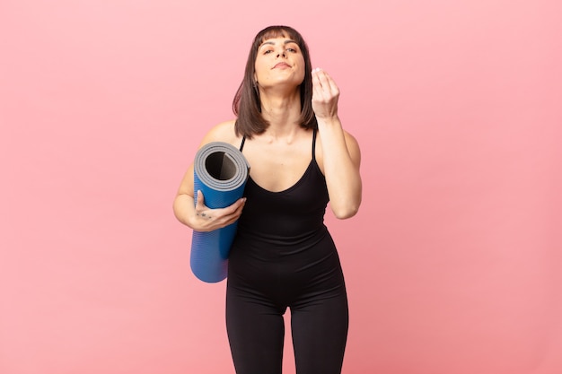 ¡Mujer deportista haciendo gesto de capice o dinero, diciéndole que pague sus deudas!