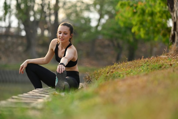 Mujer deportiva activa estirando las piernas antes del entrenamiento matutino Deporte físico y concepto de estilo de vida saludable