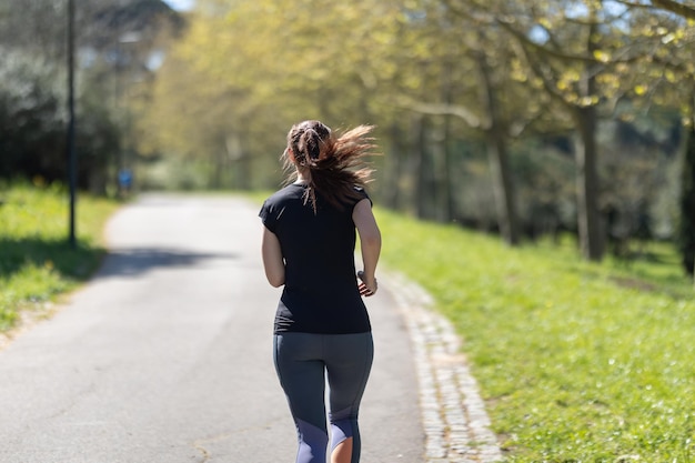 Mujer deportiva adulta trotando en el parque