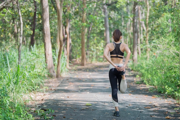 Mujer deportiva asiática estirando el cuerpo respirando aire fresco en el parqueGente tailandesaConcepto de fitness y ejercicioJogging en el parque