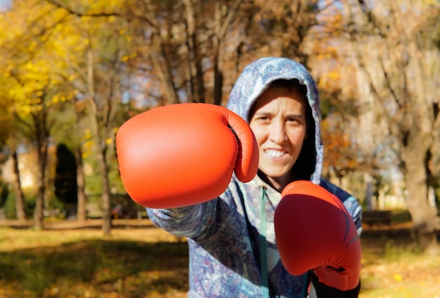 Mujer deportiva boxeando frente a la cámara en un parque