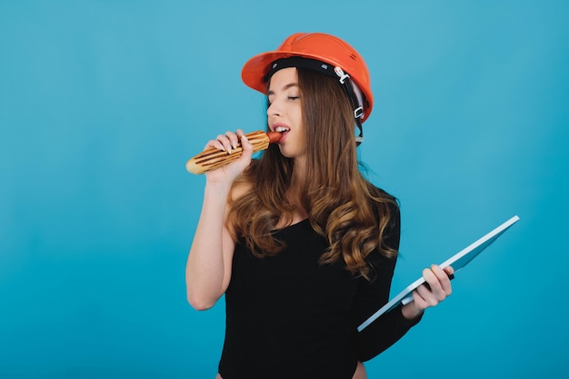 mujer deportiva comiendo hot dog con fondo azul