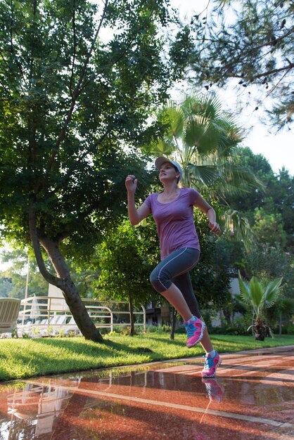 Foto mujer deportiva corriendo en la acera temprano en la mañana