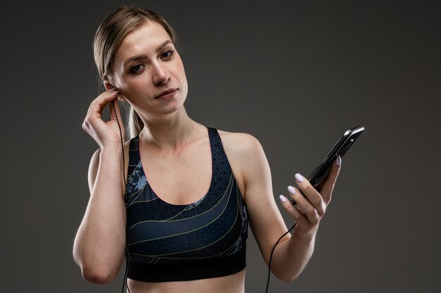 Mujer deportiva escucha música con auriculares grandes