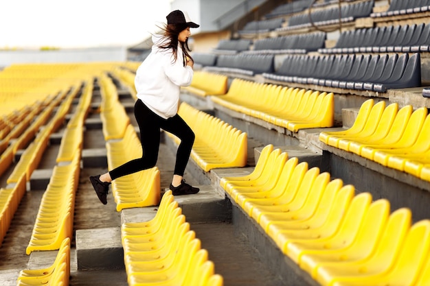 Mujer deportiva en el estadio en las escaleras en verano Mujer haciendo ejercicios