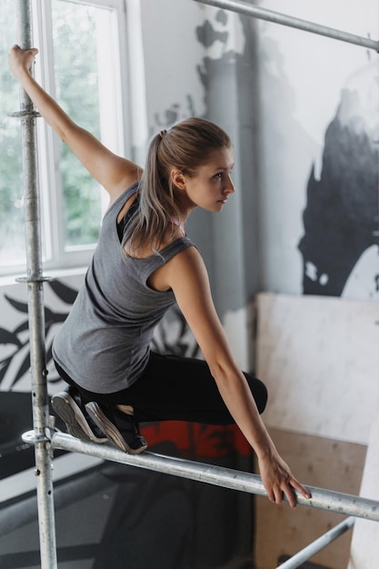 Mujer deportiva haciendo parkour en el gimnasio Atleta femenina practicando freerunning