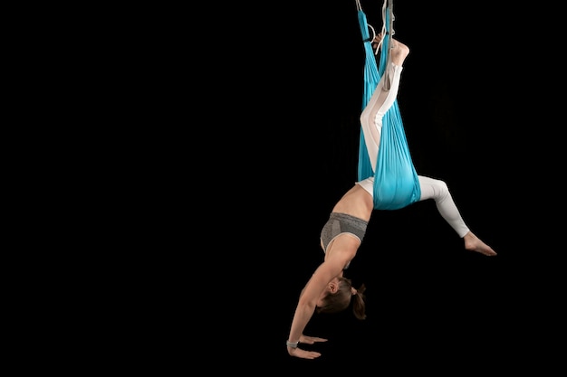 Foto mujer deportiva practica posiciones de yoga antigravedad de inversión fly yoga gimnasia aérea copiar espacio