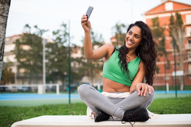 Mujer deportiva tomando selfies en el parque