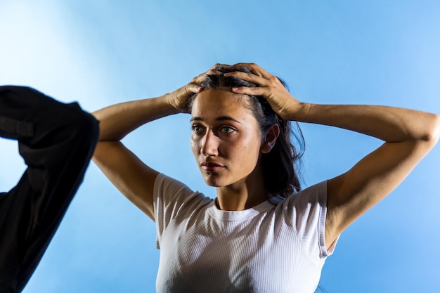 Mujer deprimida contra un fondo azul.