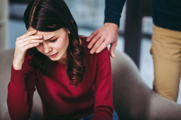 Mujer deprimida sentada en el sillón