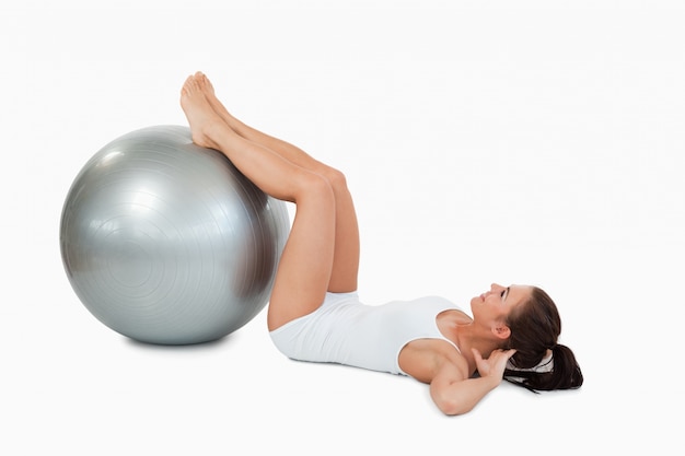 Mujer desarrollando sus abdominales con una pelota