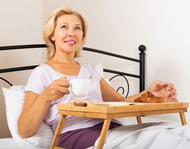 Mujer desayunando en la cama