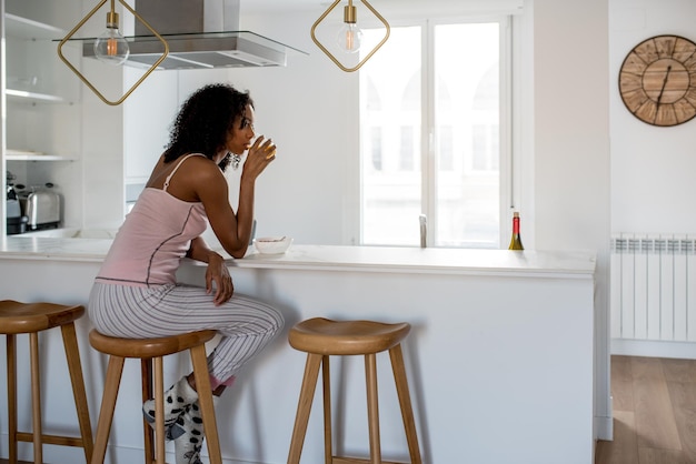 Mujer desayunando con teléfono móvil