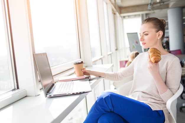 Mujer desayunando en el trabajo