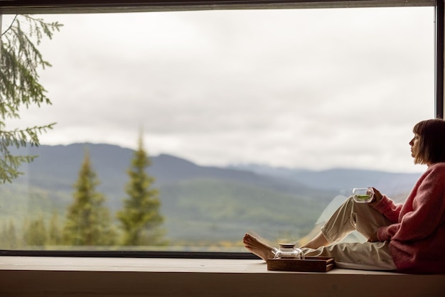 Foto mujer descansa en casa con vistas panorámicas a las montañas