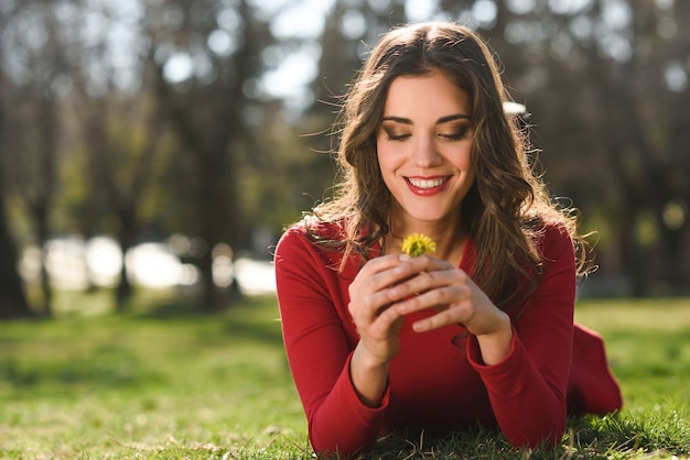 Mujer descansa en el parque con dientes de león