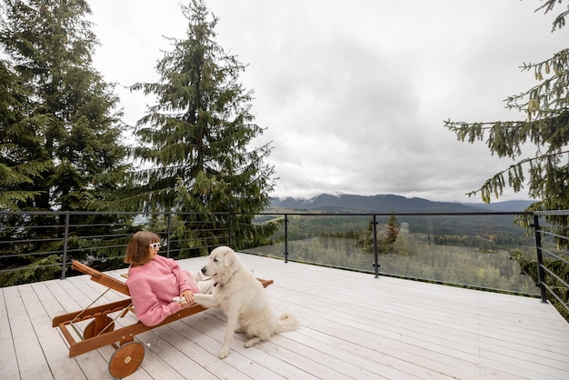 La mujer descansa en la terraza en las montañas