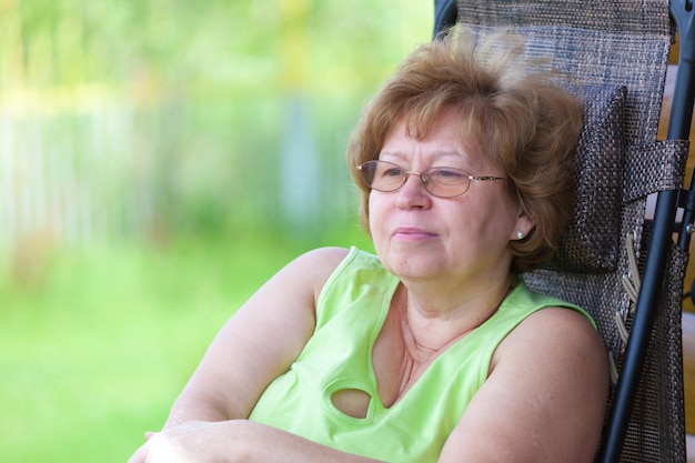 Una mujer descansa en una tumbona cerca de la casa.