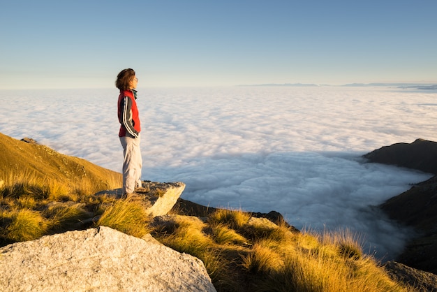 Mujer descansando en la cima de la montaña