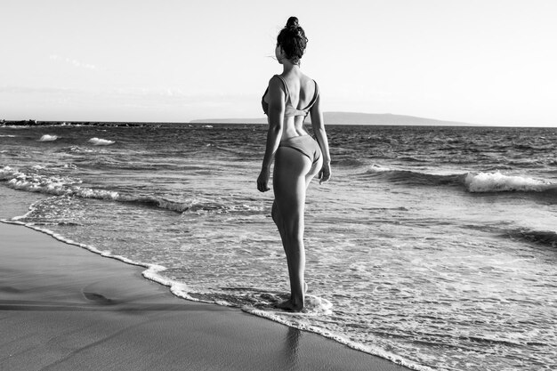 Mujer descansando en la costa del mar. Hermosa mujer joven disfrutando de un día en la playa.