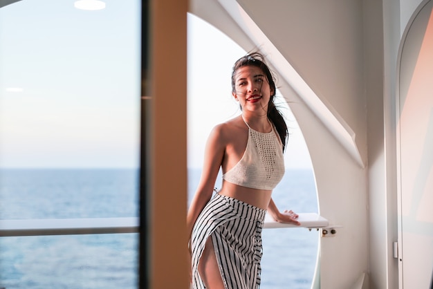 Mujer descansando en un crucero disfrutando de la vista al mar desde el balcón