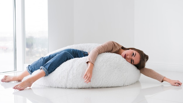 Foto mujer descansando en un puf y aburrido