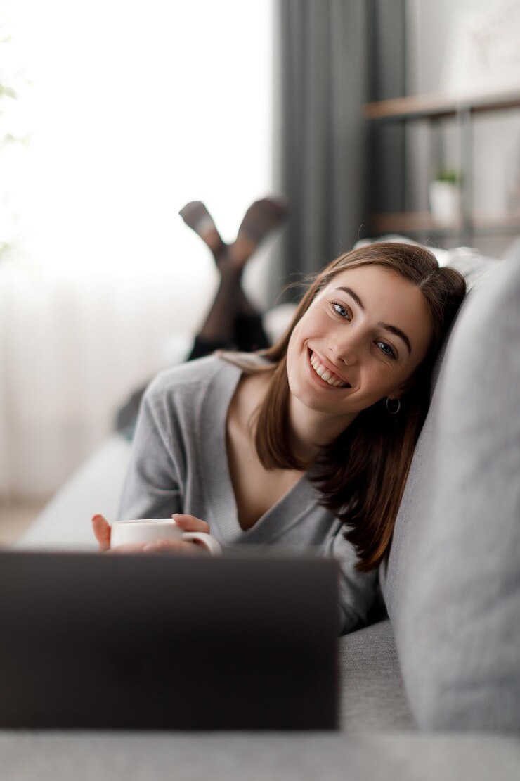 Mujer descansando con té y laptop