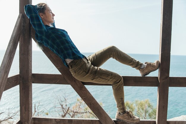 Mujer descansando en la terraza de madera