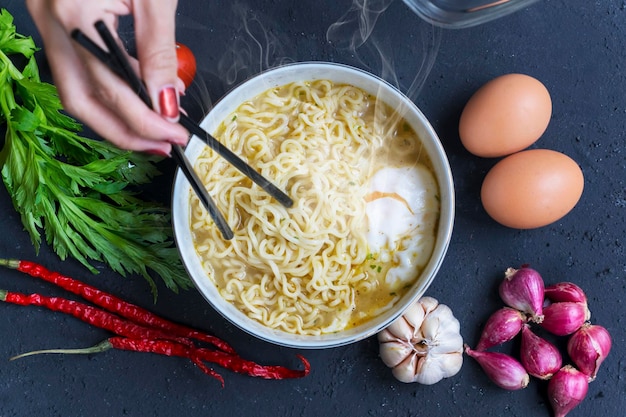 Mujer desconocida comiendo fideos instantáneos