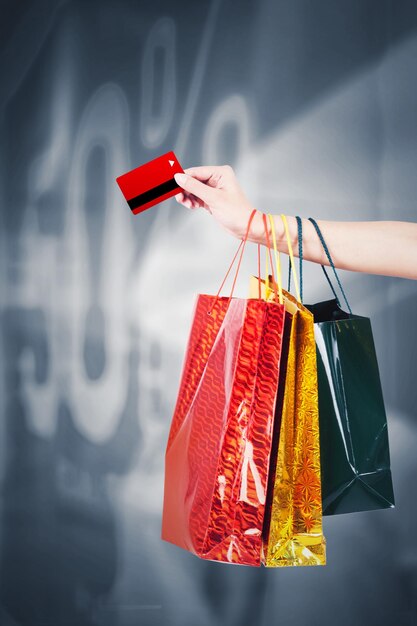 Mujer desconocida tiene tarjeta de crédito y bolsas de compras.